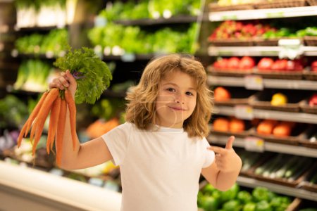 Téléchargez les photos : Enfant choisissant des légumes dans un magasin de supermarché. Des enfants dans un supermarché. Ventes, réductions dans les supermarchés alimentaires et achats. Enfant dans la baie du marché légumes et fruits. Enfant acheter au supermarché - en image libre de droit