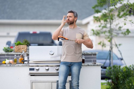 Photo for Middle aged man preparing barbecue grill outdoor. Man cooking barbecue grill at backyard. Chef preparing food on barbecue. Millennial man grilling meat on barbecue grill. Bbq party. Meal grilling - Royalty Free Image