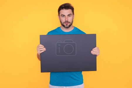 Photo for Information concept. Man with blank placard. Demonstrating copy space for your text or design. Man showing empty advertisement board on studio background. Blank placard with copy space, signboard - Royalty Free Image