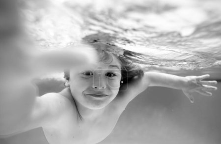 Photo for Underwater boy in the swimming pool. Cute kid boy swimming in pool under water - Royalty Free Image