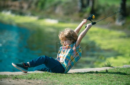 Foto de Niño con hilandero en el río. Retrato de niño emocionado pescando. Chico en embarcadero con varilla. Concepto de pesca - Imagen libre de derechos