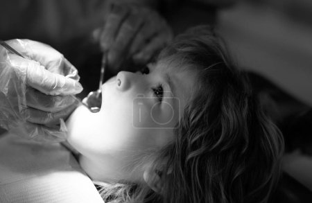 Foto de Examen de salud dental para niños. Un niño con un dentista en un consultorio dental. Dentista revisando los dientes de los niños. Procedimiento dentista de cerca de los dientes de los niños - Imagen libre de derechos