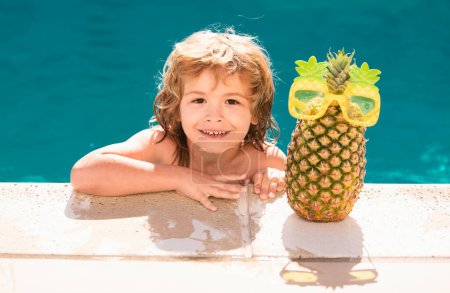 Téléchargez les photos : Joyeux enfant jouant dans la piscine. Vacances d'été pour enfants. Ananas d'été - en image libre de droit