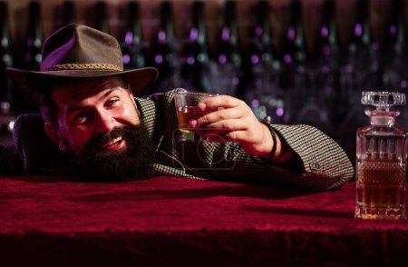 Foto de Emocional, divertido barbudo hipster borracho sostiene whisky de cristal. Salud. - Imagen libre de derechos