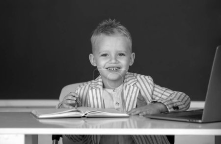 Photo for Kid writing in class. School child student learn lesson sitting at desk studying - Royalty Free Image