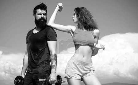 Photo for Sportive fitness couple, bearded man and sexy woman working out outdoors, sportive couple training with dumbbells, muscular coupl outdoor - Royalty Free Image