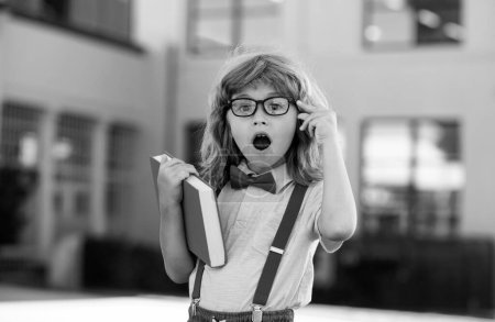 Photo for Happy excited kid in glasses is going to school for the first time. Pupil go study. Child boy with bag go to elementary school. Child of primary school. Back to school - Royalty Free Image