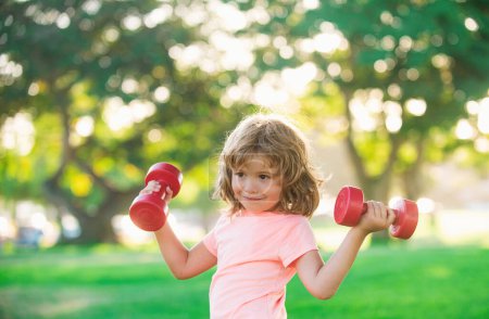 Photo for Boy exercising in park. Kids sport. Active healthy lifestyle. Sport child with dumbbell - Royalty Free Image