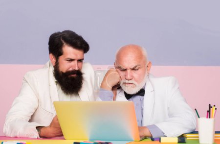 Téléchargez les photos : Concept de remue-méninges, deux hommes d'affaires pensant au bureau. Travailleurs masculins travaillant sur le lieu de travail. Homme d'affaires utilisant un ordinateur portable au travail - en image libre de droit