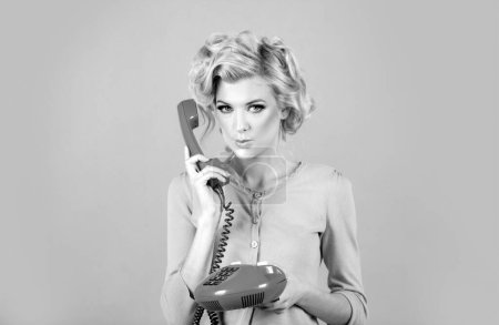 Photo for Charming girl holding phone handset, conversation on telephone. Portrait of woman with handset isolated studio background. Fashioned surprised girl talking on the phone - Royalty Free Image