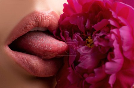 Foto de Los labios lamen las flores de cerca. Hermosos labios de mujer con rosa - Imagen libre de derechos