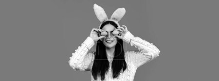 Photo for Easter banner. Funny woman wearing bunny ears and having fun with Easter eggs. Playing hunt eggs. Happy Easter concept - Royalty Free Image