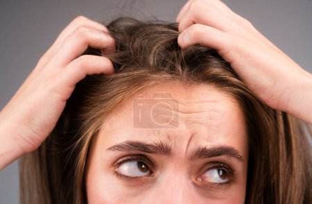 Photo for Sad woman looking at damaged hair, the hair loss problem. Studio isolated portrait, copy space - Royalty Free Image