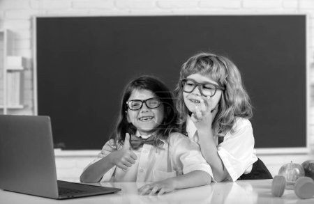 Photo for School friends. Friendly classmates in school uniform at lesson. Boy and girl school children at school. Schoolkids and friendship, friends. Classmates couple, young primary students - Royalty Free Image