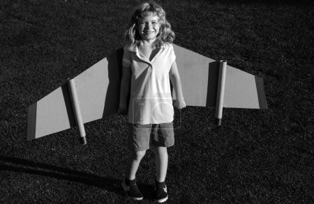 Téléchargez les photos : Joli garçon rêveur jouant avec un avion en carton. Enfance. Fantaisie, imagination - en image libre de droit