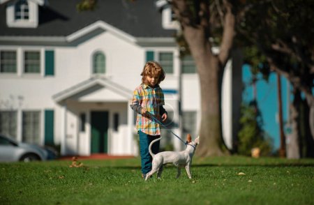 Foto de Perro corre desde niño jugando juego de persecución en el césped de verano. Cachorro feliz - Imagen libre de derechos