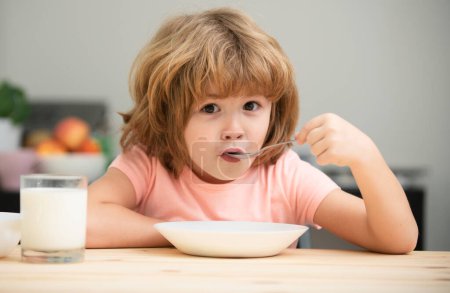 Téléchargez les photos : Nourriture et boisson pour les enfants. Enfant mangeant des aliments sains. Mignon petit garçon manger de la soupe pour le déjeuner - en image libre de droit