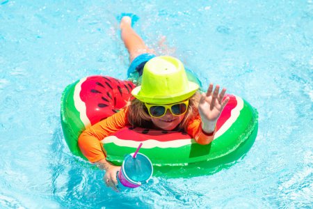 Téléchargez les photos : Enfant dans la piscine. Activité estivale. Mode de vie sain des enfants. Été nager et se détendre, nager sur l'anneau dans la piscine, bord de piscine - en image libre de droit