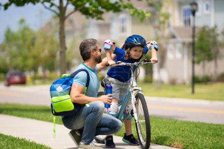 Photo for Father and son are riding bike together on summer weekend. Happy playful dad with excited kid son riding a bicycle on weekend. Sporty family. Fathers day. Father teaching and support child - Royalty Free Image