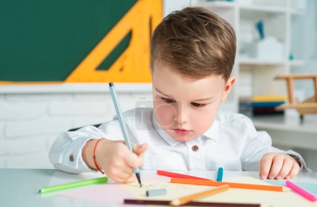 Photo for Cute little preschool kid boy in a classroom. Elementary school and education. Educational kids process - Royalty Free Image
