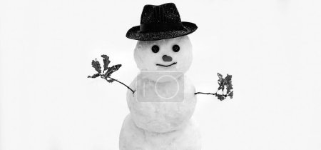 Téléchargez les photos : Drôle de bonhomme de neige sur fond de neige floue. Bonhomme de neige avec chapeau - en image libre de droit