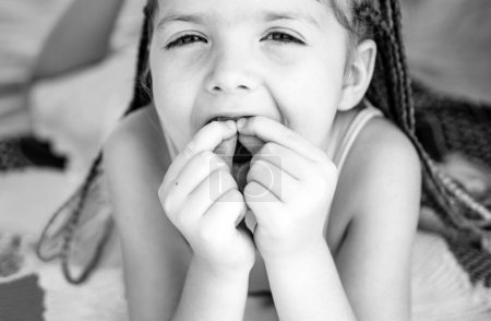 Foto de Dientes de niños. Chica sonriente sosteniendo el diente perdido. Cara graciosa de cerca - Imagen libre de derechos