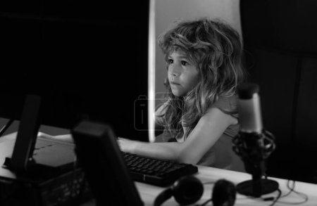 Téléchargez les photos : Enfant utilisant PC la nuit. Enfant avec ordinateur dans une pièce sombre - en image libre de droit
