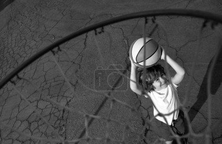 Foto de Niño jugando al baloncesto con baloncesto. Vista de la pelota voladora a la cesta desde la parte superior, niño jugar baloncesto - Imagen libre de derechos