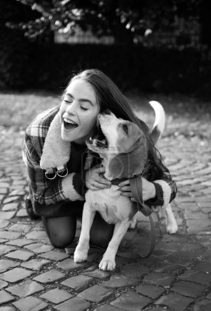 Foto de Mujer abrazando cachorro perro al aire libre. Chica feliz consigue perro encantador, juega y abraza. Humanos y perros - Imagen libre de derechos