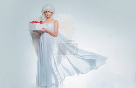 Chica con alas de ángel y un vestido blanco. Chica ángel. Mujer Cupido

