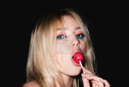 Photo for Desire. Sexy woman face. Sensual glamorous attractive lady licking yummy sugary lollypop with red lips. Girl sucks lollipop. Flirting sexy female pop art style - Royalty Free Image