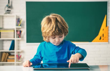 Photo for Schoolkid or preschooler learn. Education, school, technology and internet concept - little pupil with tablet pc in school - Royalty Free Image