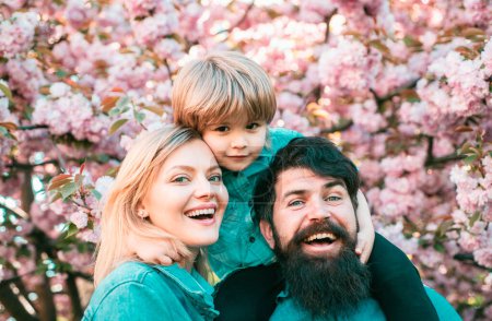 Photo for Portrait of happy family in blooming Garden. Spring time. Mother father and son - Royalty Free Image