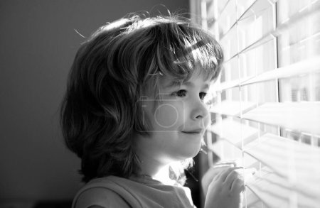 Photo for Protect yourself. Stay home in self isolation. COVID-19 Lockdown. Child looking through window. Qarantine concept. Coronavirus pandemic - Royalty Free Image