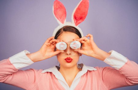 Téléchargez les photos : Joyeuse Pâques. Une jeune femme aux oreilles de lapin. Empreinte baiser rouge à lèvres sur oeuf de Pâques - en image libre de droit