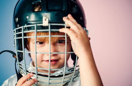 Photo for Sport childhood. Future sport star. Sport upbringing and career. Boy cute child wear hockey helmet close up. Safety and protection. Protective grid on face. Sport equipment. Hockey or rugby helmet. - Royalty Free Image