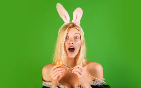 Foto de Mujer sensual con orejas de conejo y sosteniendo colorido huevo de Pascua se ve sorprendido en la cámara. Concepto muy alegre de las vacaciones de Pascua. Gente loca. Feliz Pascua. Hermosa rubia sensual - Imagen libre de derechos