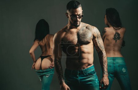 Photo for Sexy dominant man with a muscular body posing near naked young woman in studio. Sexy girls. Muscular nude hunk. Romantic and love. Intimate relationship and sexual relations. Passion and sensual - Royalty Free Image