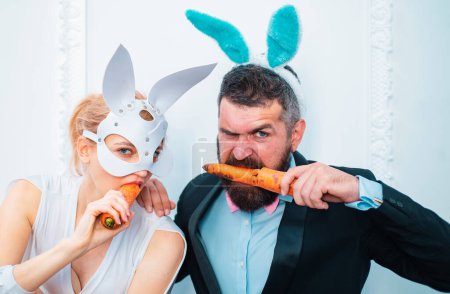 Photo for Happy easter and funny easter day. Bunny rabbit ears costume. Surprised bunny couple wearing bunny ears and eat carrot - Royalty Free Image