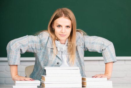 Foto de Retrato de una joven, segura y atractiva estudiante seria con libros en el aula de la escuela - Imagen libre de derechos
