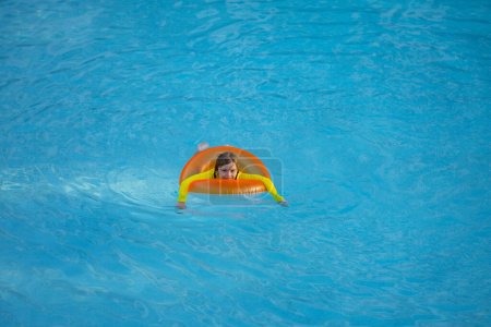 Foto de Vacaciones de verano. Niño con anillo inflable en piscina. Vacaciones de verano. Vacaciones de verano. Fin de semana de verano para niños. Niño en la piscina. Niño flotando en la piscina - Imagen libre de derechos