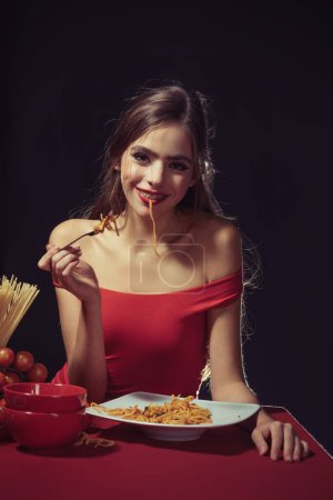 Photo for The woman savors the spaghetti with a sensual touch. She enjoys each bite of the pasta in a sensual manner. Food sensual experience. Italian food meal sensual satisfaction - Royalty Free Image