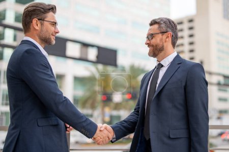 Photo for Businessman handshake with partner. Welcome business. Two businessmen shaking hands. Business men in suit shaking hands outdoors. Handshake between two businessmen - Royalty Free Image