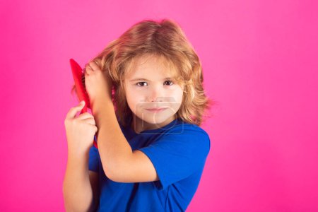 Photo for Comb and hair brush concept. Little kid combing hair, isolated studio background - Royalty Free Image