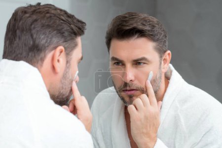 Beauty male face cream. Beauty routine. Beauty man with perfect skin. Anti-aging and wrinkle cream. Concept of male beauty. Close-up face of man applying cream to skin. Skincare cosmetics concept