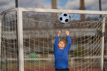 Photo for Child boy hold classic football ball in park. Kid hold football ball, banner. Kid with football ball. Sport, soccer hobby for kids. Little football player posing with soccer ball - Royalty Free Image
