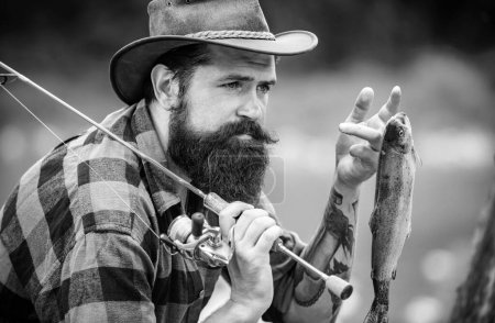 Téléchargez les photos : Portrait d'homme avec canne à pêche, pêcheurs en plein air dans l'eau de la rivière. Passe-temps de pêche d'été - en image libre de droit