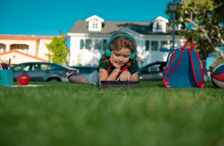 Photo for Kids education. Schoolboy with school supplies in the garden. Beautiful boy are happy learning - Royalty Free Image