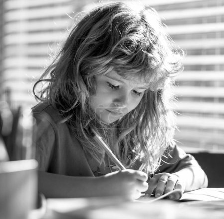 Foto de Niño escribiendo deberes en la clase escolar. Estudiante preadolescente haciendo su tarea en casa. Estudio de niños. Educación y aprendizaje para niños. Lindo niño haciendo la tarea en el aula - Imagen libre de derechos