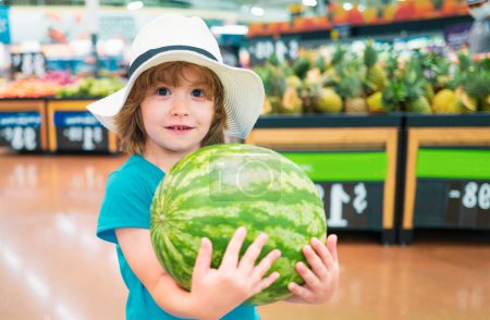 Foto de Niño sosteniendo sandía en el supermercado. Hortalizas en tienda - Imagen libre de derechos